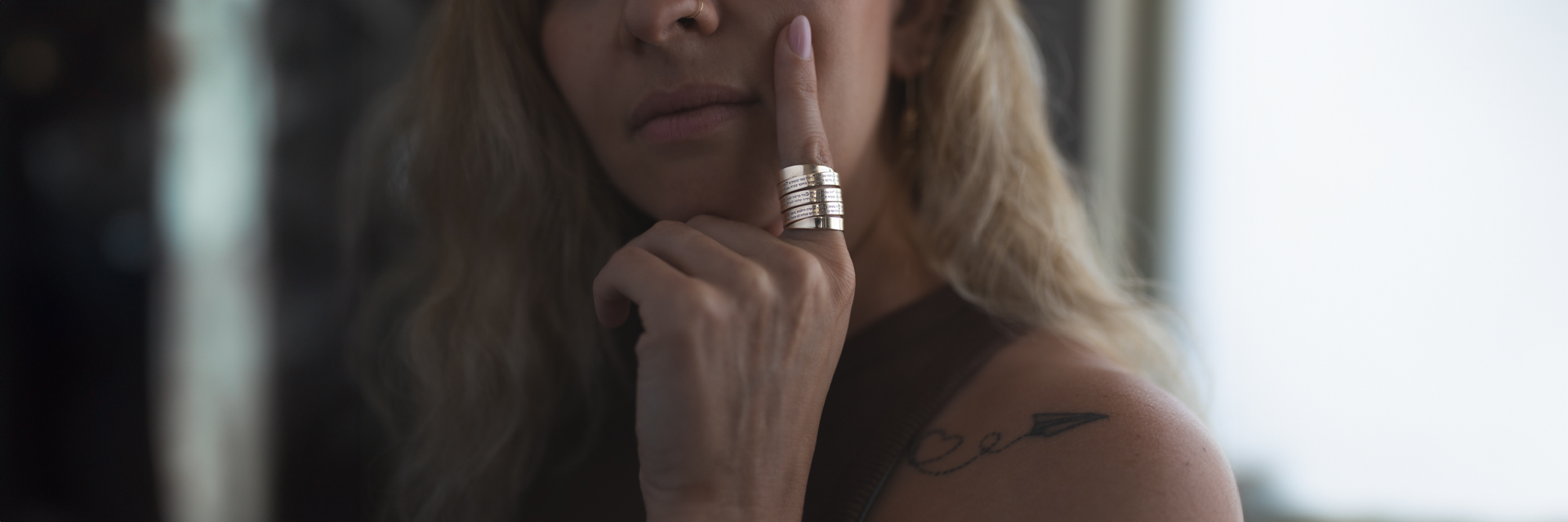 Woman wearing stacked silver rings engraved with Hebrew blessings - handcrafted rings for women