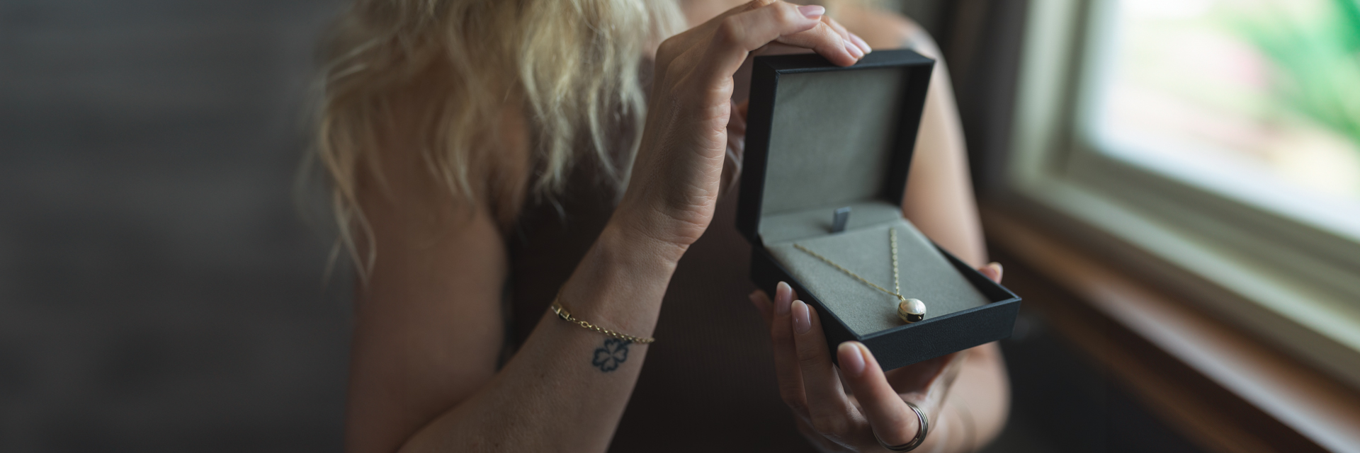 Hand holding a gift box with a gold necklace - perfect spiritual Jewish gift