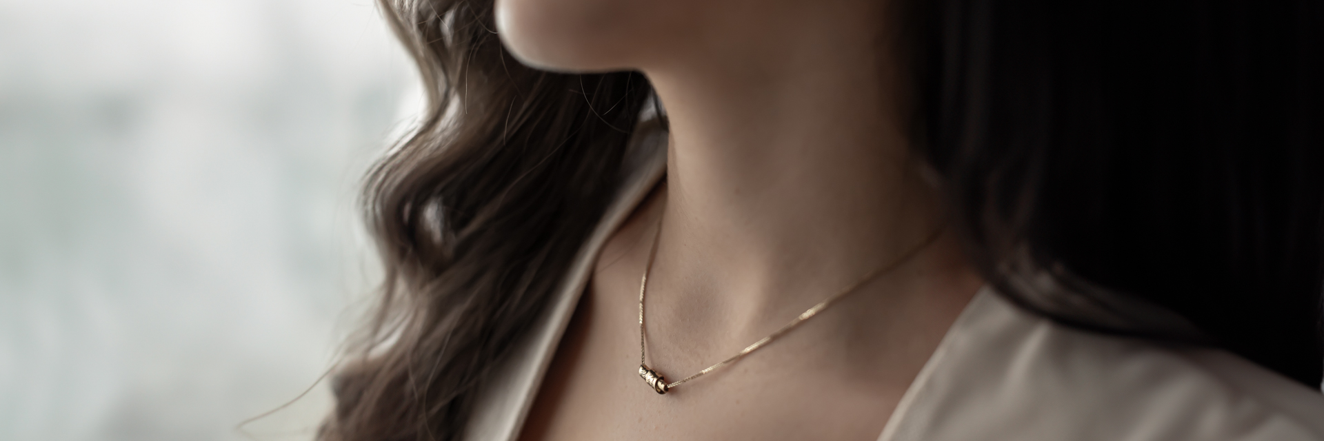 Young woman wearing a meaningful gold Hebrew necklace - perfect Bat Mitzvah gift